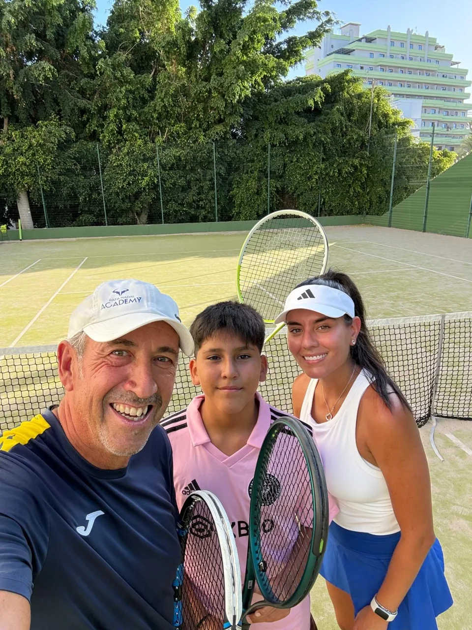 Juan con dos alumnos en una foto junto a la red